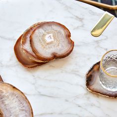 three slices of agate and two glasses on a marble table