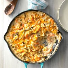 a casserole dish with carrots, mushrooms and cheese in it on a table