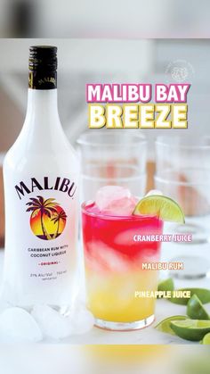 a bottle of malbu bay breeze next to two glasses filled with ice and limes