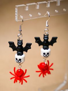 two halloween themed earrings hanging from hooks