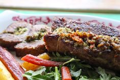 a plate with meat, vegetables and bread on it