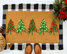 a pair of brown shoes sitting on top of a door mat next to christmas decorations