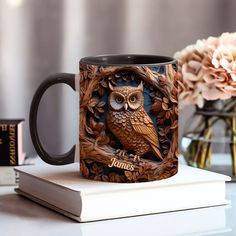 a coffee mug with an owl on it sitting on top of a table next to some books