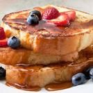 two pieces of french toast with syrup and berries on top