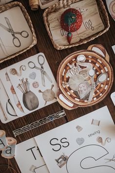 some paper and scissors on a table with other crafting items in baskets next to it