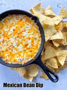 mexican bean dip with tortilla chips in a cast iron skillet next to it