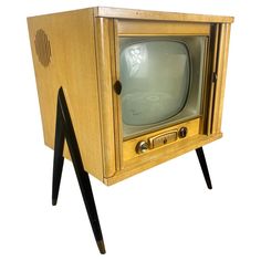 an old tv sitting on top of a wooden stand