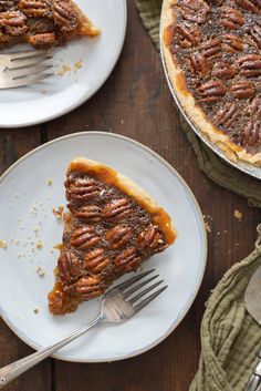 a slice of pecan pie on a plate with a fork next to the pie