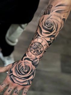 a man's arm with a rose and clock tattoo design on it, in black and white