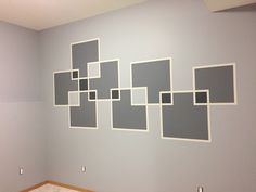 an empty room with gray and white squares on the wall