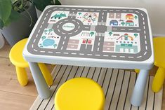 a child's play table with yellow stools and a toy road map on it