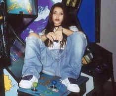 a young woman sitting on top of a skateboard in front of a tv set