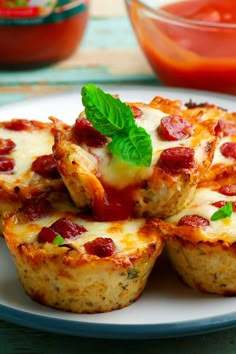 several mini pizzas on a plate with sauce