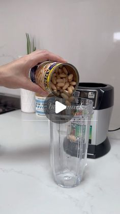 a person is pouring peanuts into a blender