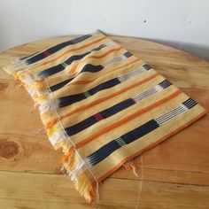 an orange and blue striped blanket sitting on top of a wooden table