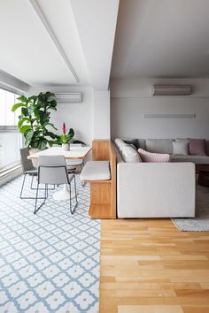 a living room filled with furniture and a large window next to a wooden dining table