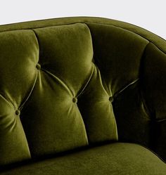 a green velvet couch with buttons on it