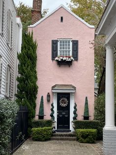 a pink house with black shutters and white trim