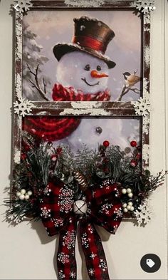 a snowman with a top hat and scarf is hanging on the wall next to a christmas wreath