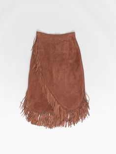 70s vintage suede fringed skirt, brown. A beautiful brown suede leather high-rise skirt that features a hidden metal zip on the back and a hook closure. A one of kind piece that can be worn in all seasons! Our recommended size: XS / Small  Label says: No size label Material: Suede Condition: Good; a few imperfections on the material such as darkening/spotting - Please see the last image (not colour accurate)*. Measurements in inches: Waist: 12.5 (25) Hip: 17.5 (35) Length without fringes: 25 Len Bohemian Brown Bottoms With Fringe, Bohemian Brown Fringe Bottoms, Chic Brown Fringe Skirt, Stagecoach Outfits, Style Long Skirt, Suede Fringe Skirt, Western Vibes, High Rise Skirt, Vintage Suede