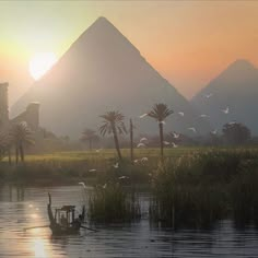 the sun is setting over some water with birds flying in front of pyramids and palm trees