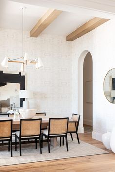 the dining room table is surrounded by chairs and mirrors, along with an arched doorway