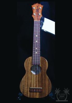 an acoustic guitar is on display in a case with a name tag hanging from it's neck