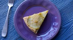 a purple plate with a piece of pie on it and a fork next to it