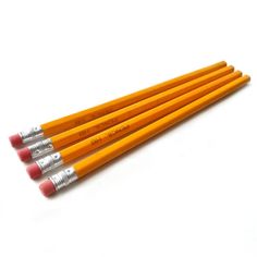 four pencils are lined up on a white surface