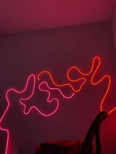 a chair sitting in front of a wall with neon lights on it's side