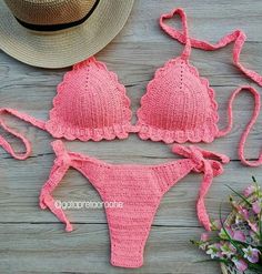 a pink bikinisuit and hat sitting on top of a wooden table