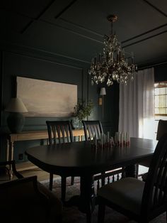 a chandelier hangs from the ceiling above a dining room table with six chairs