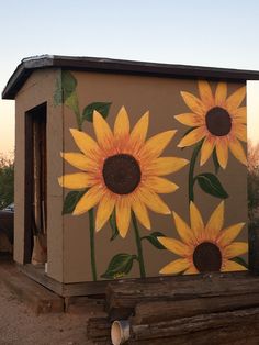 a painted outhouse with sunflowers on it