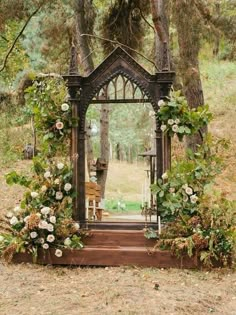 a wooden structure with flowers and greenery around it