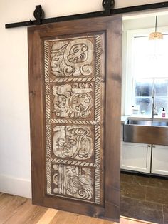 a wooden door with an intricate design on the front and side panels, in a kitchen