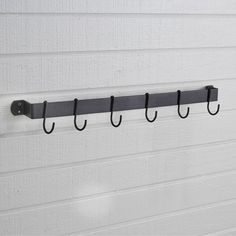 a coat rack with four hooks hanging from it