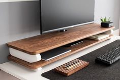 a flat screen tv sitting on top of a wooden shelf next to a keyboard and mouse