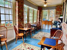 a room filled with wooden chairs and tables next to each other in front of windows