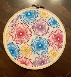 a colorful embroidery project on a wooden table