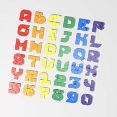 multicolored letters and numbers are arranged in the shape of magnets on a white surface