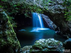 a small waterfall in the middle of a forest