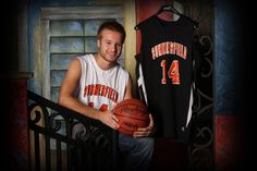 a man holding a basketball next to a shirt