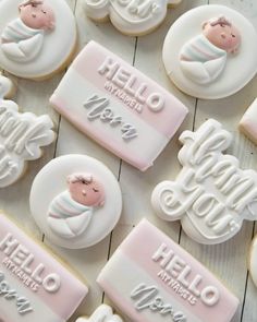 cookies decorated with baby's name and images are on a white wooden table top