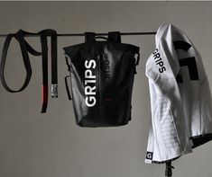 the gym bag is hanging on a clothes line with other sports gear and equipment attached to it