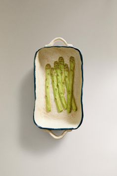 a bowl with asparagus in it is hanging on the wall