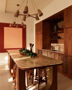 a large kitchen island in the middle of a room with wooden cabinets and counter tops