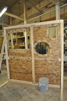 the inside of a building that is being built with wood and plywood panels on the walls