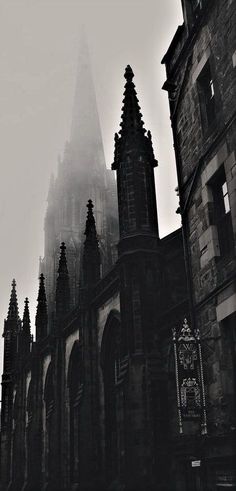 an old gothic church with spires in the fog