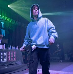 a man standing on top of a stage holding a nintendo wii game controller in his hand