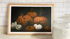 a painting of pumpkins and gourds on a counter